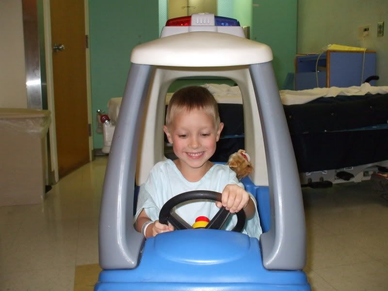 Malachi riding hospital toys while waiting for surgery.